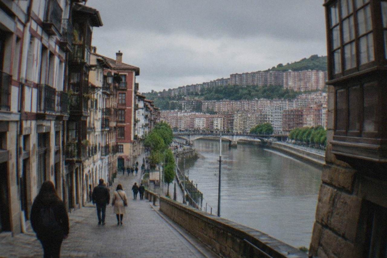 Narrow medieval street in Bilbao's Old Town with traditional timber buildings and pedestrians
