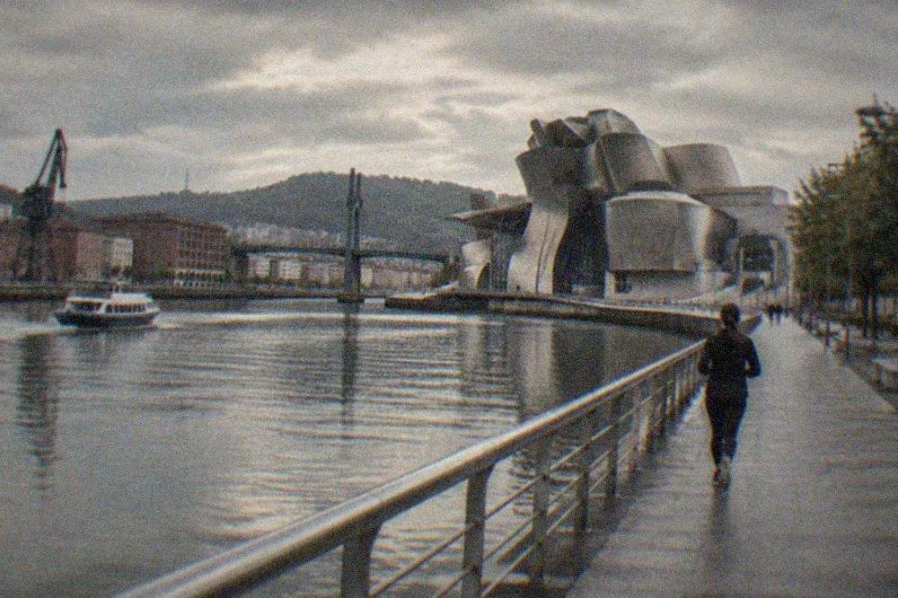 Evening light over the Nervion estuary in Bilbao with the Guggenheim Museum's titanium curves beside the water
