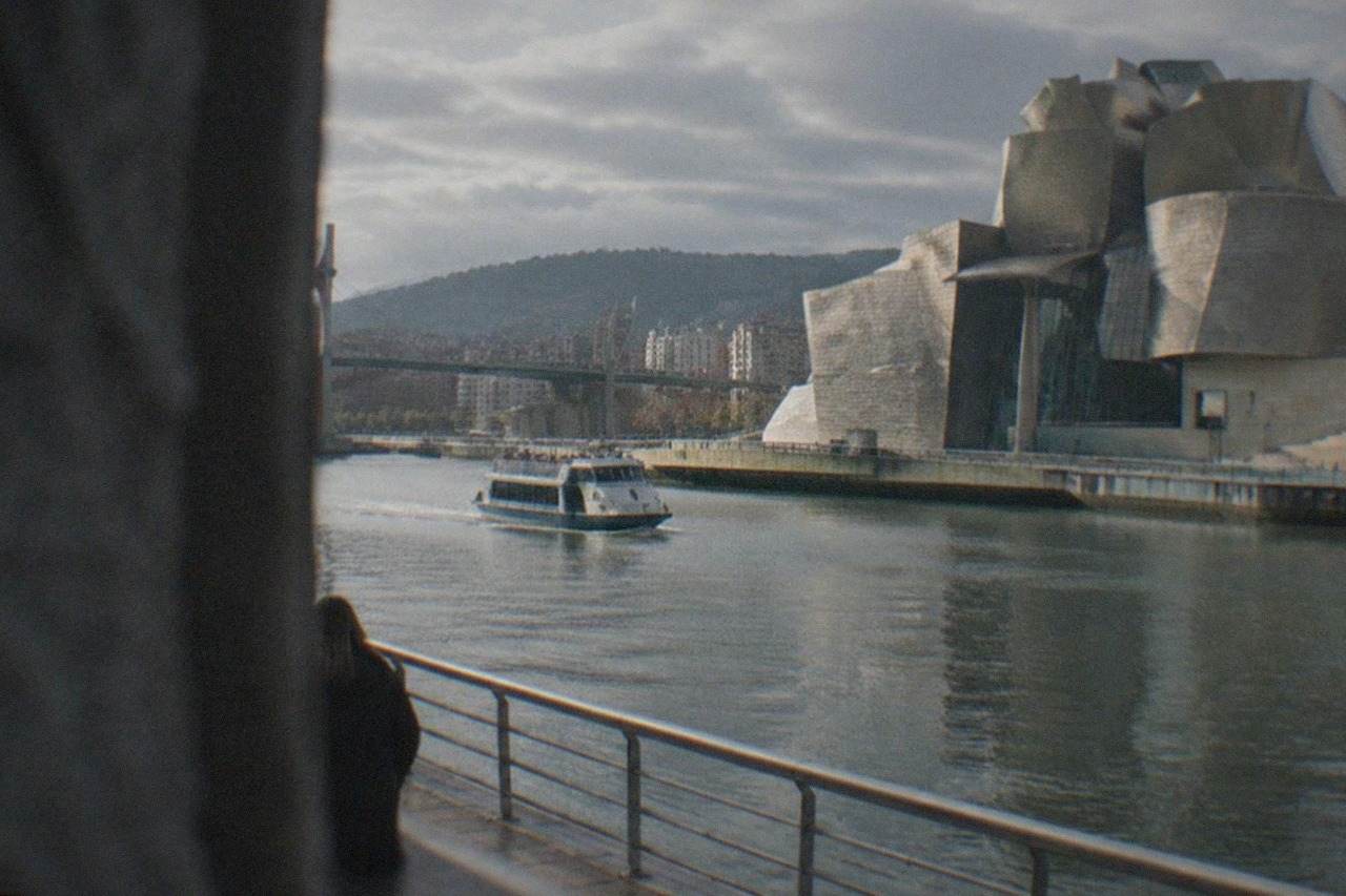 The titanium curves of the Guggenheim Museum Bilbao beside the Nervion estuary on a bright morning