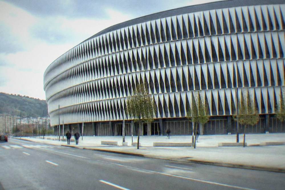 The exterior of San Mames stadium in Bilbao seen from a nearby street, with its curved modern facade