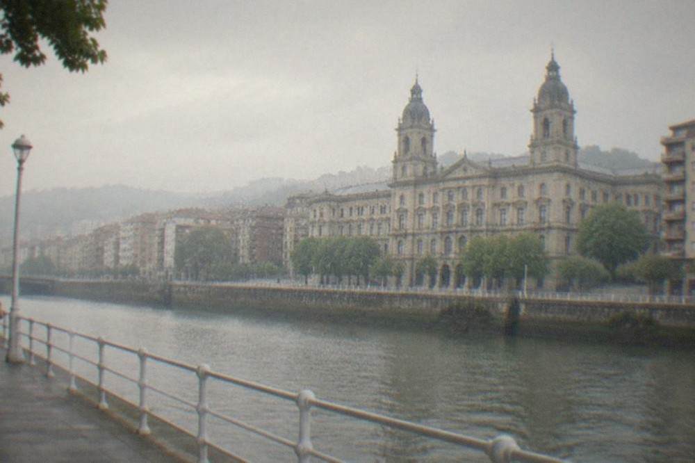 The ornate riverside facade of the University of Deusto building seen from the opposite bank of the Nervion