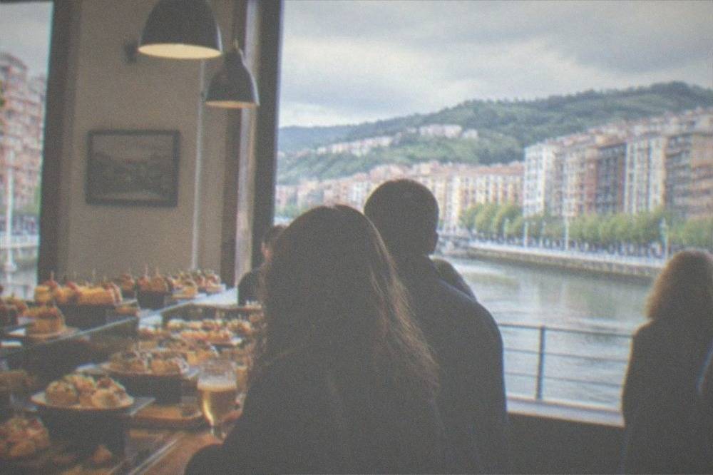 Interior of a traditional Bilbao pintxos bar with counter food on display and customers standing at the bar