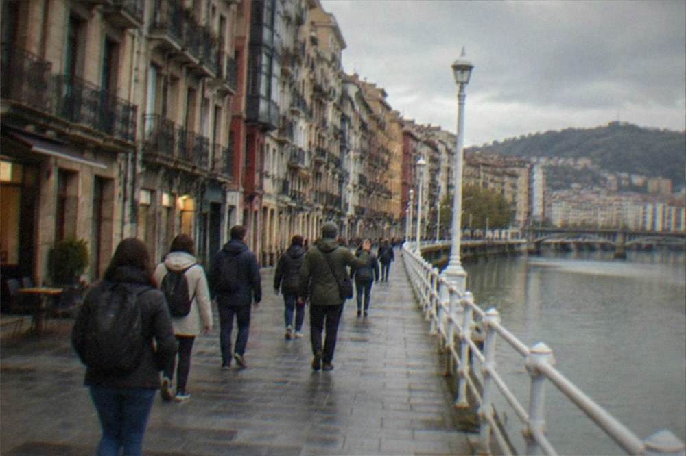A tour group with a guide walking along a riverside promenade in the late afternoon