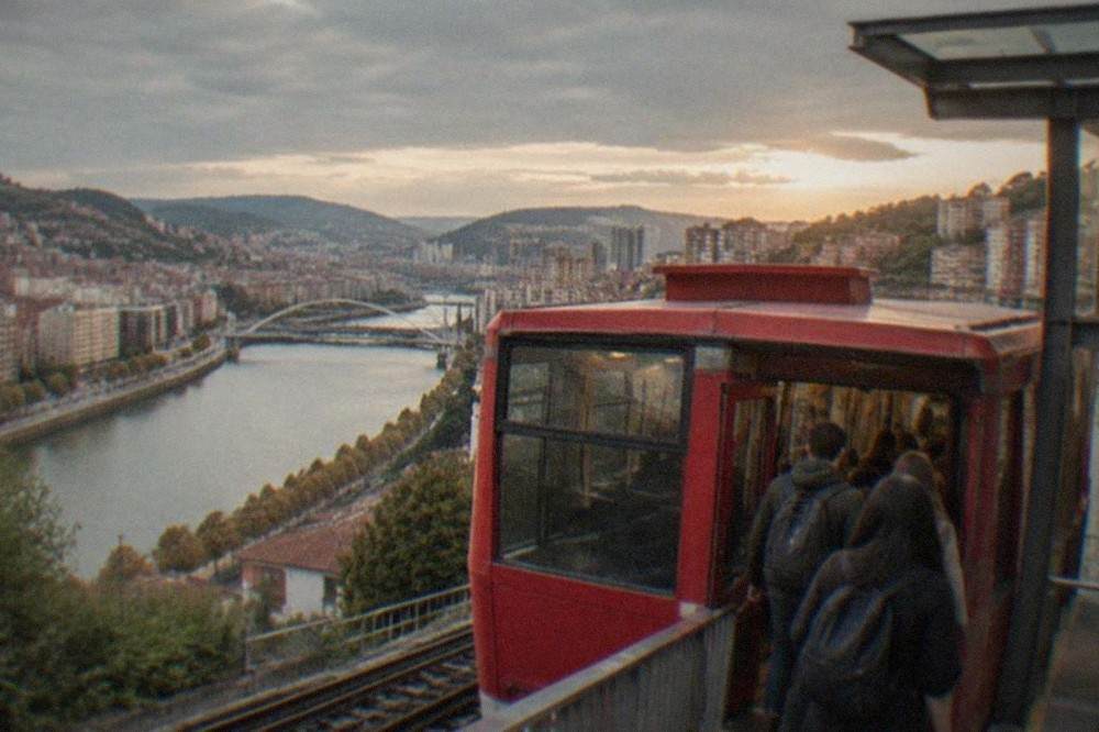 Passengers boarding a red funicular carriage at the lower station in Bilbao