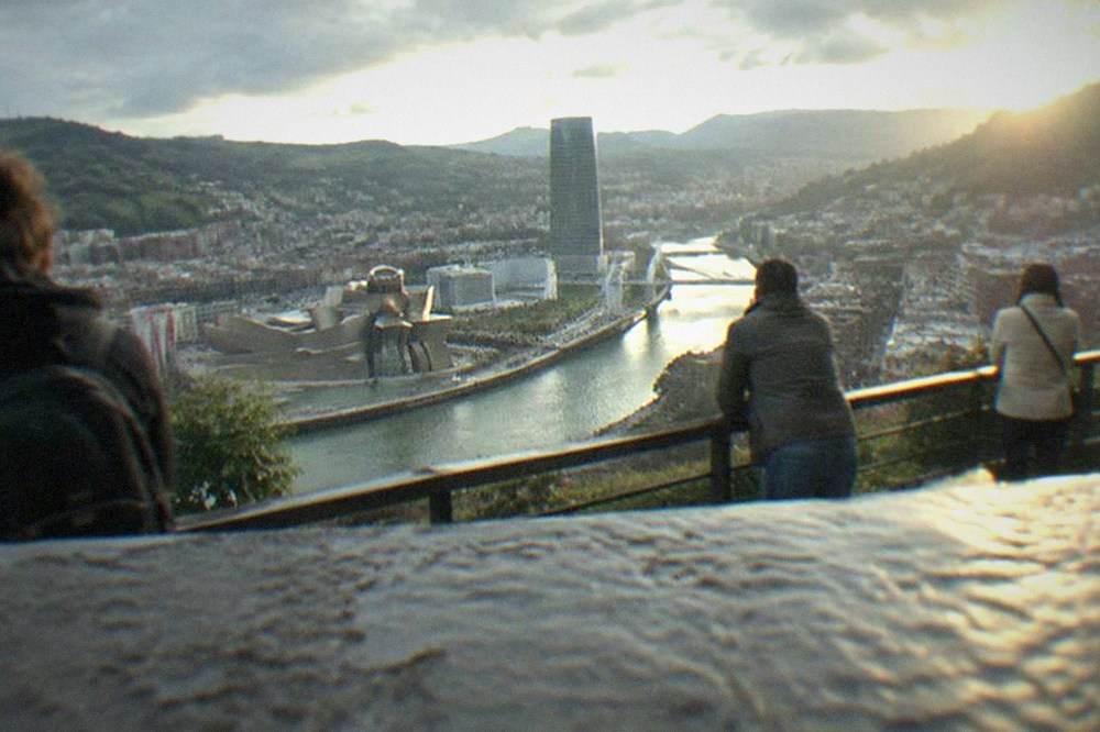 Visitors leaning on the railing of the Artxanda viewpoint overlooking central Bilbao and the estuary