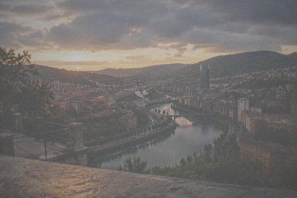 The Artxanda viewpoint terrace at golden hour with warm light on the Bilbao skyline