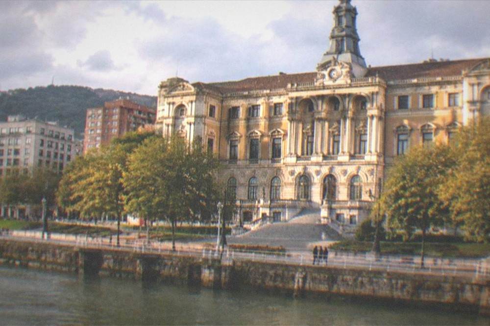 The City Hall facade glowing in late afternoon light above the Arenal gardens