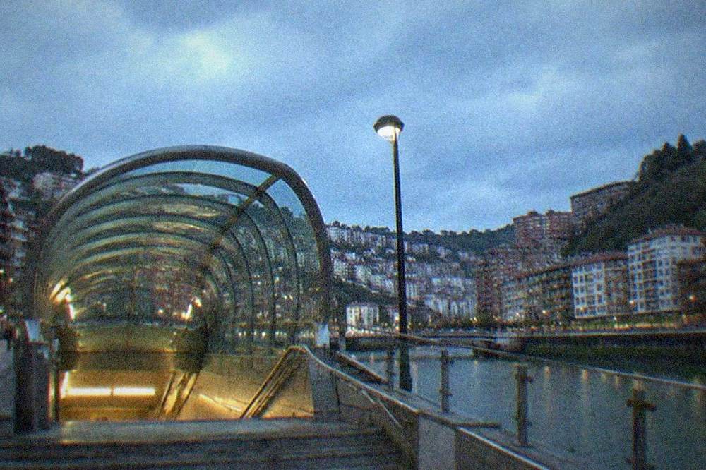 A metro station entrance with the Bilbao Metro's Fosterito canopy on a city street