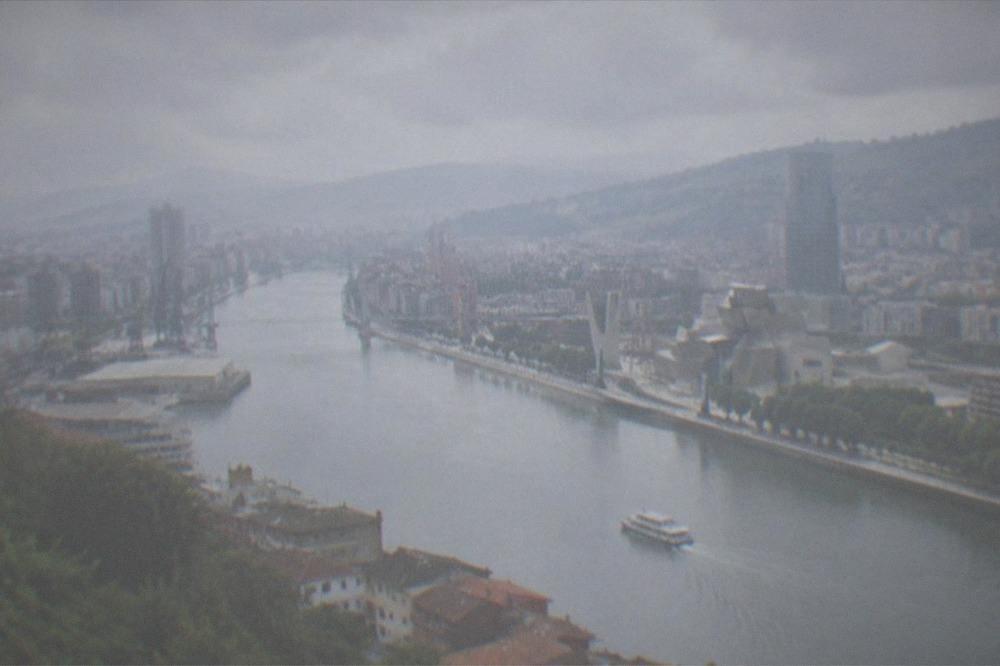 A panoramic view over Bilbao's rooftops and the Nervion estuary from a hilltop viewpoint