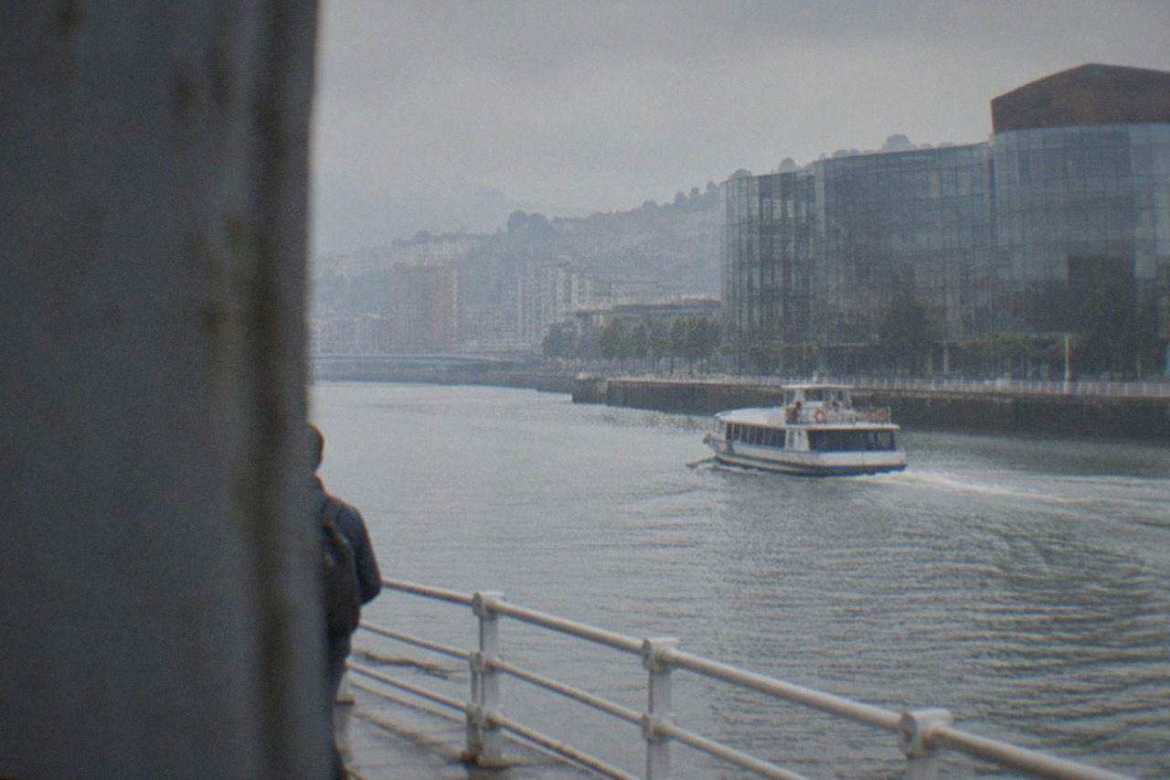 The glass and steel facade of Euskalduna Palace beside the Nervion estuary in Bilbao on an overcast day