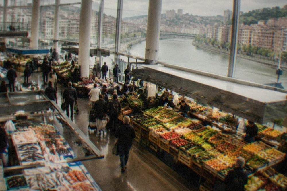Stalls of fresh produce and seafood inside a bright market hall