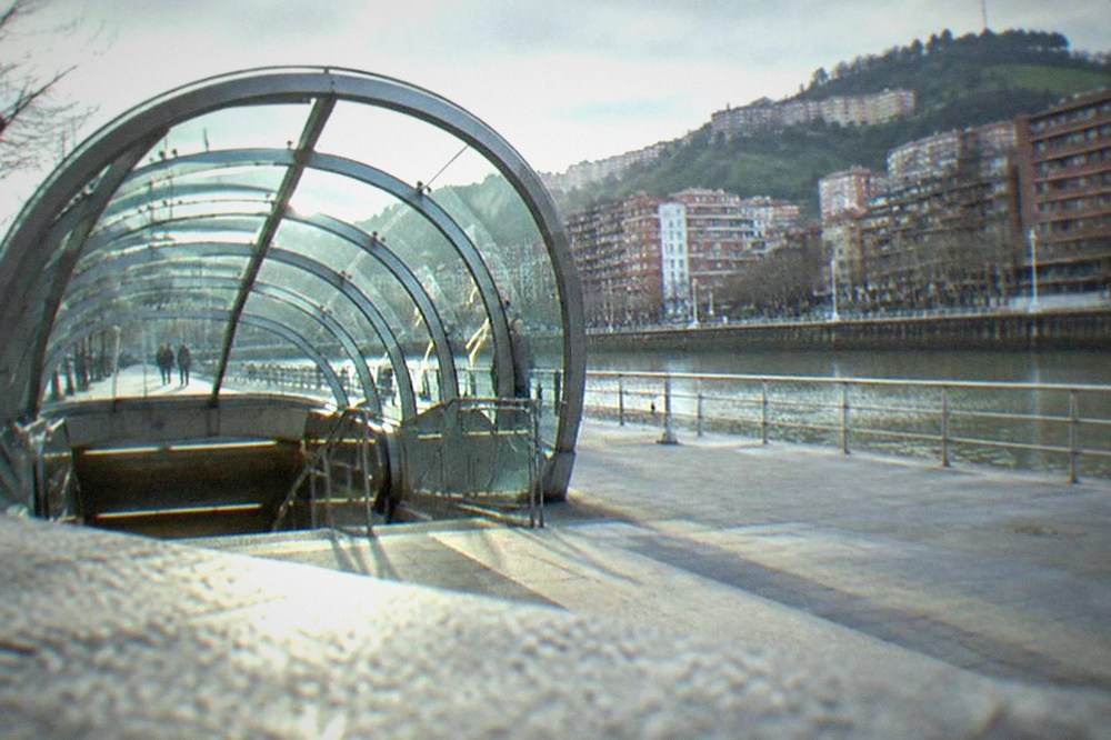 A metro station entrance in Bilbao with the Bilbao Metro's Fosterito glass canopy