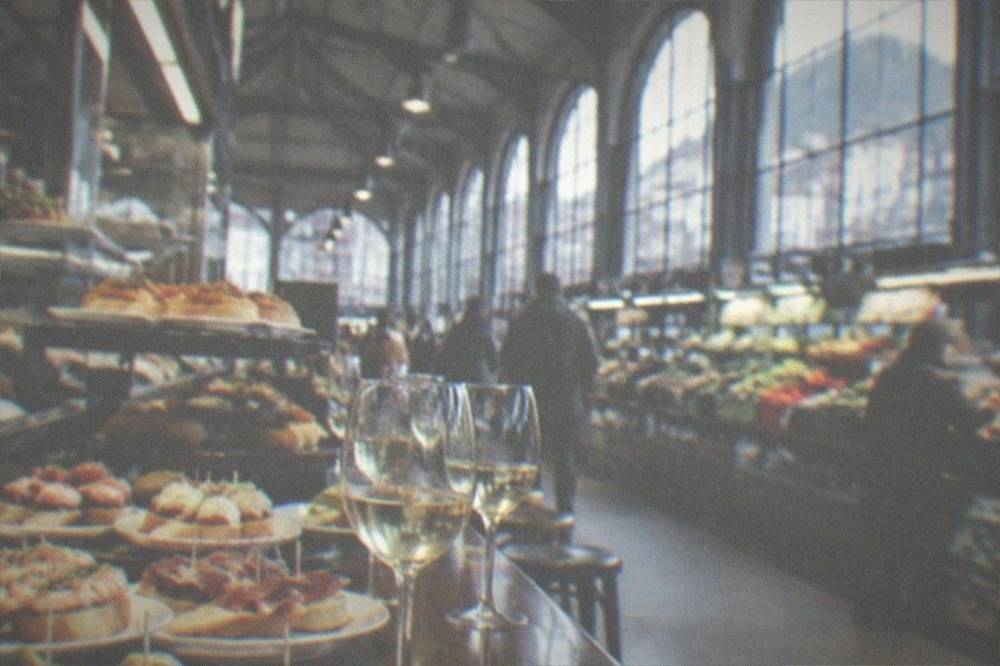 A bar counter covered with small pintxo plates and glasses of txakoli wine