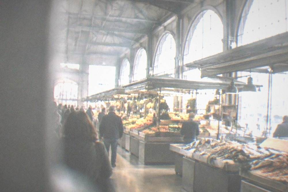 The interior of a market hall with high ceilings and stall awnings