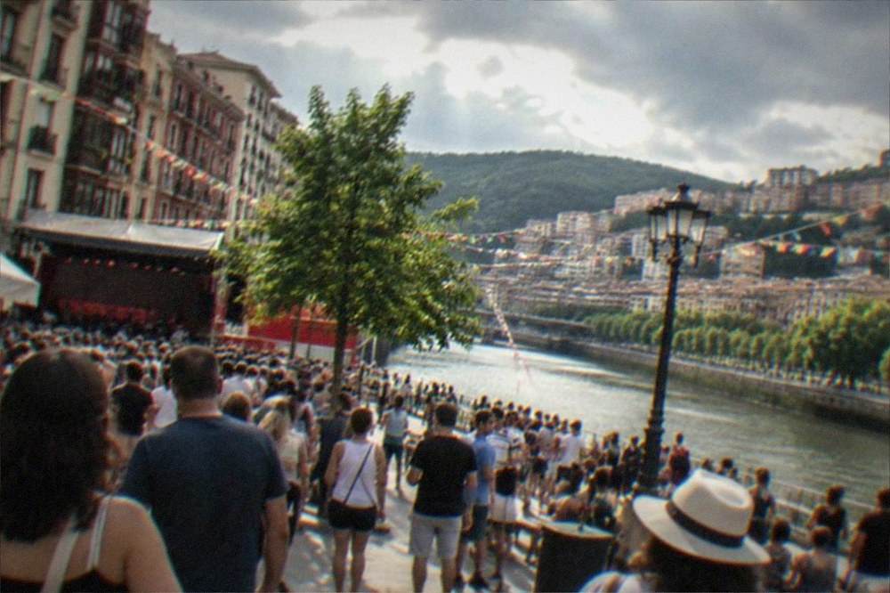 Crowds and festive decorations in a square during a Bilbao summer festival