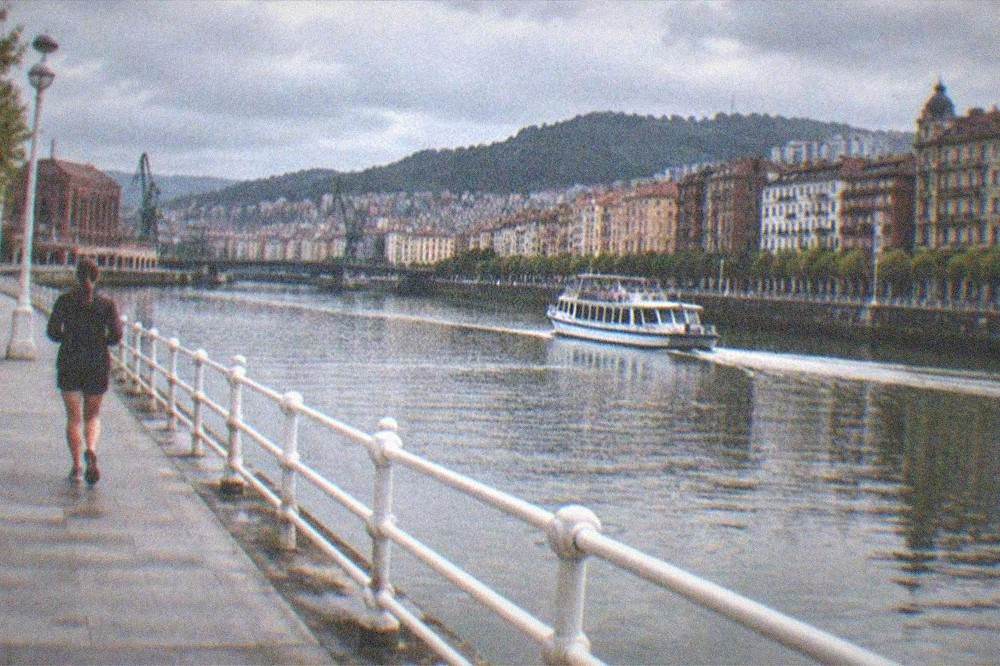 The Nervion estuary at dusk with old town buildings reflected in the water