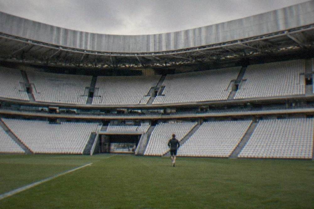 Empty steep stands of San Mamés Stadium seen from pitch level with the players tunnel in view