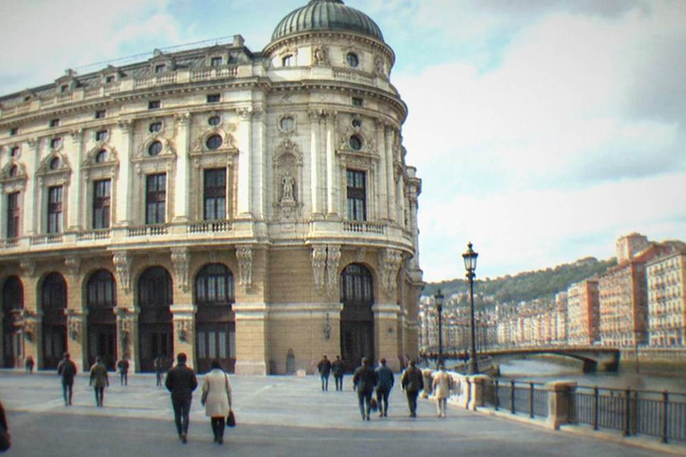 Visitors walking across the plaza in front of the theatre toward the arcades of the Old Town
