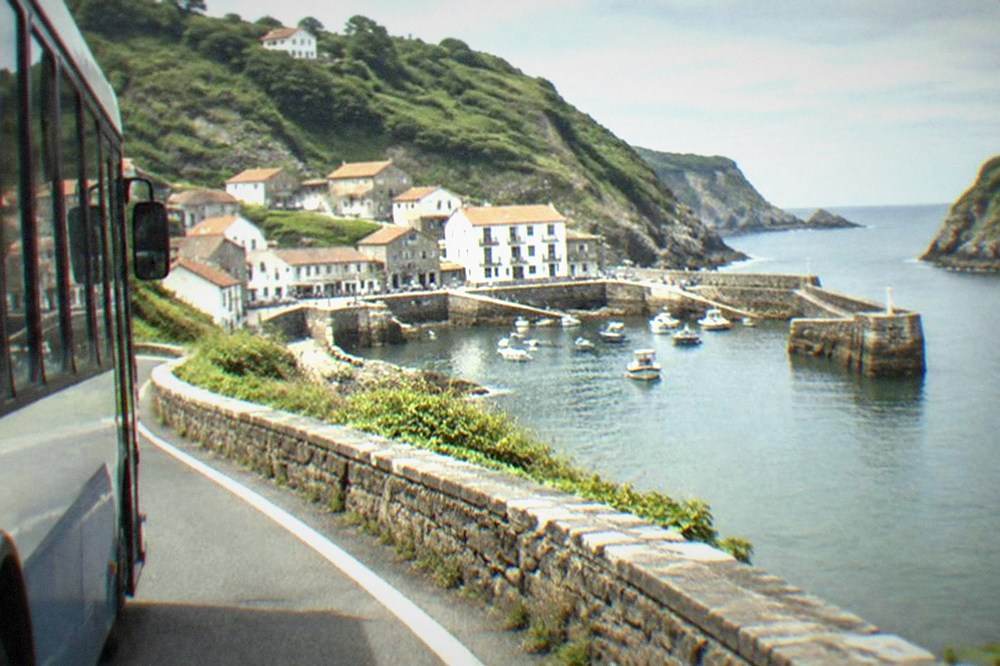 Regional bus on a narrow coast road with sea views