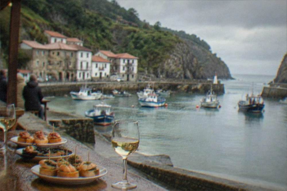 Seafood pintxos and glasses of white wine on a wooden bar counter