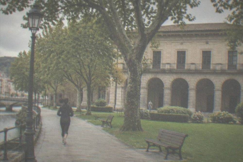 The stone facade of the Casa de Juntas assembly house with its arched portico and green garden in Gernika