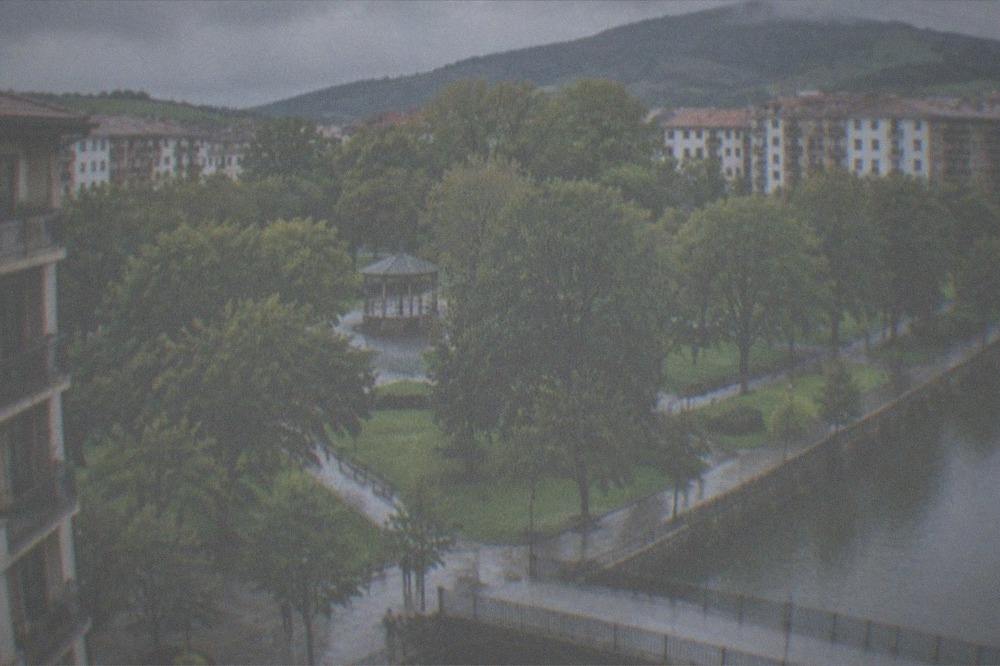 A large ceramic tile mural reproduction of a famous anti-war painting mounted on a stone wall in a Basque town street
