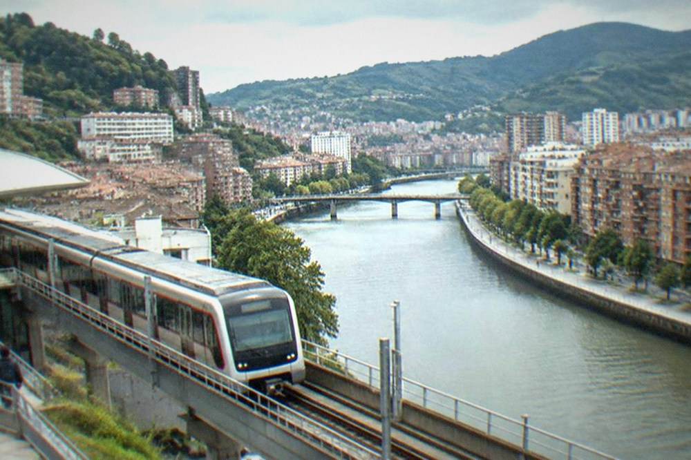 A Bilbao metro train arriving at an elevated station on the way to the coast
