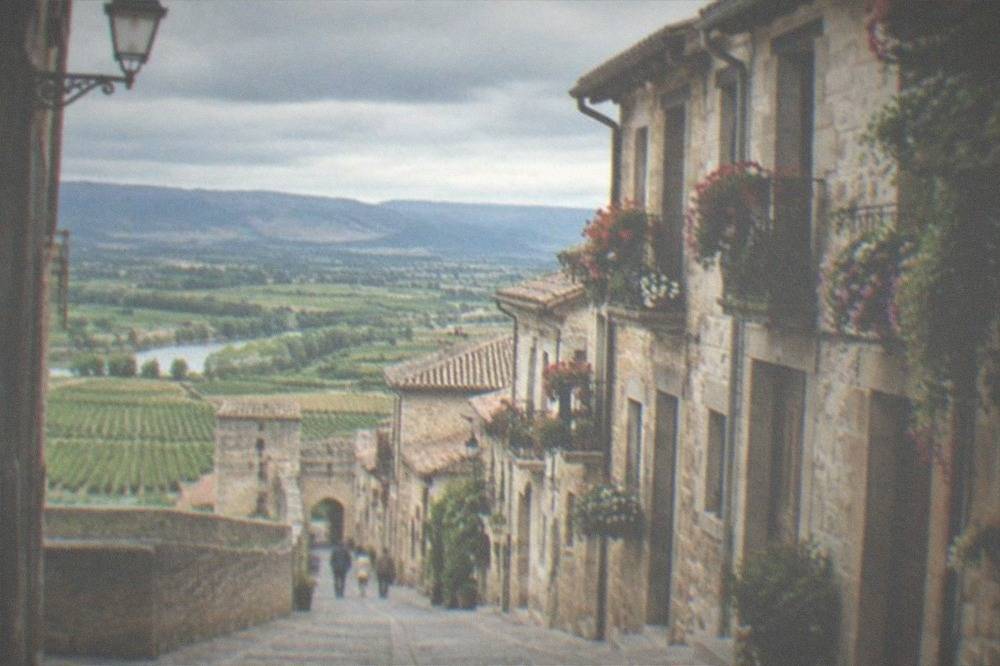 Cobbled main street in the walled old town of Laguardia with stone houses and flowered balconies