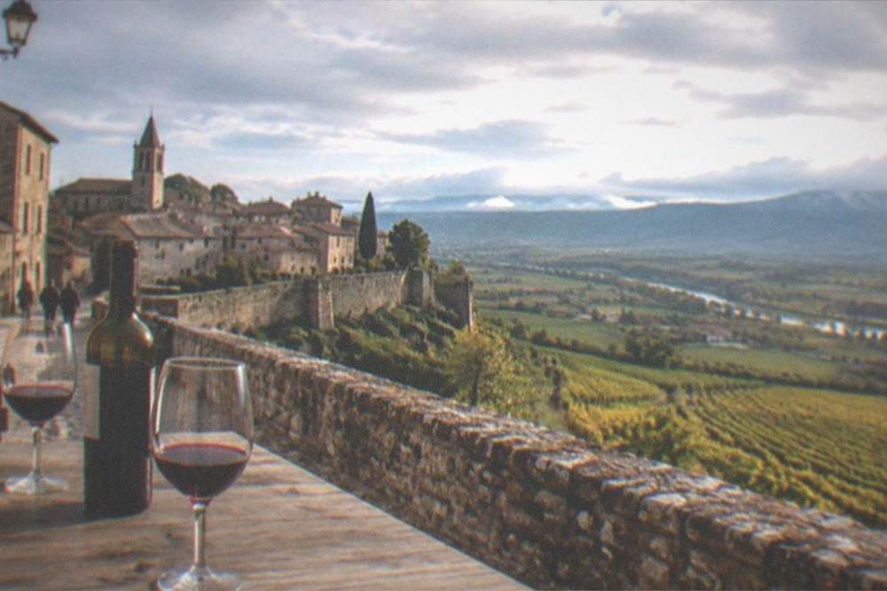 Wine glasses with red Rioja on a wooden tasting table beside an open bottle