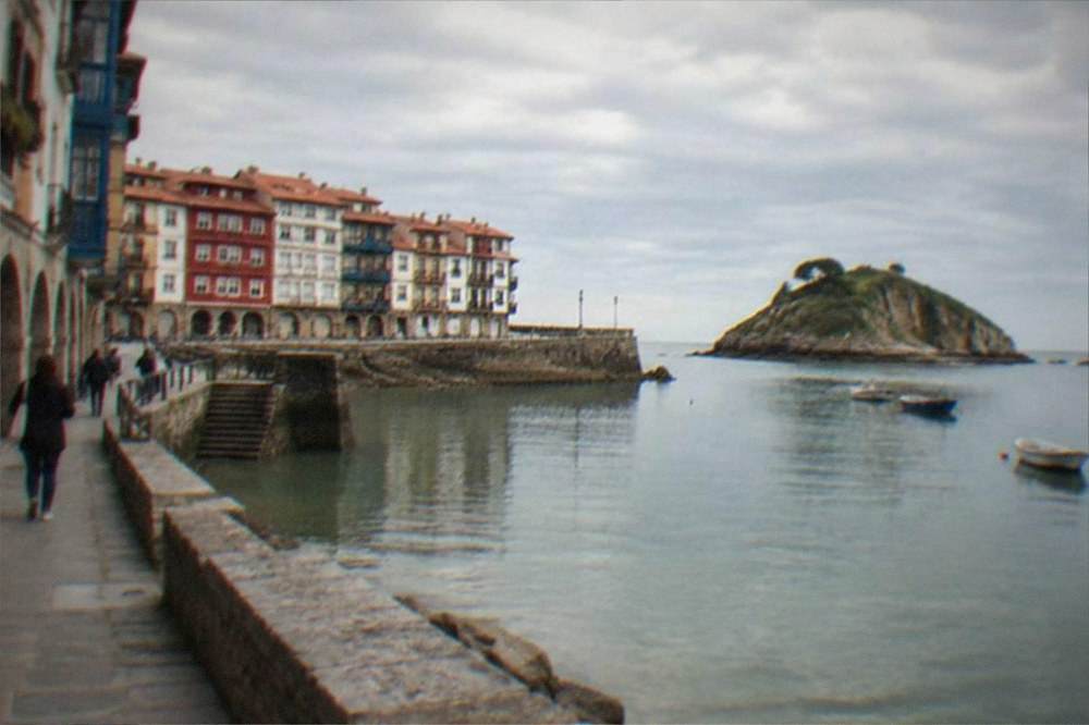 Narrow old town streets with painted facades and stone arcades in a Basque coastal town