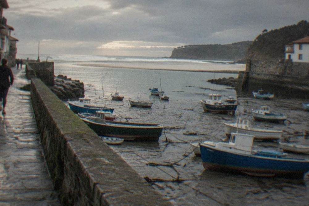 Mundaka harbour at low tide with boats resting on mud and the estuary beyond