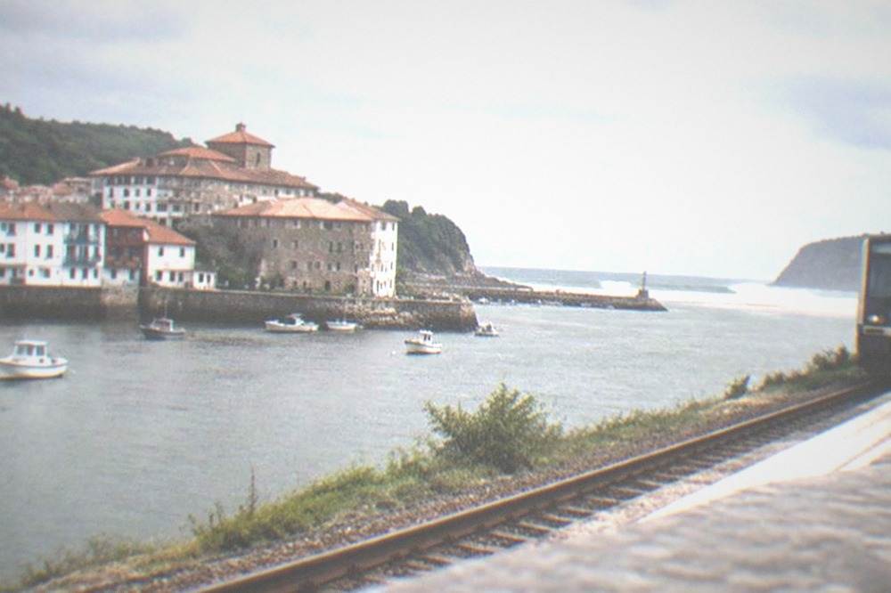 Euskotren train at a small rural station platform near the Basque coast