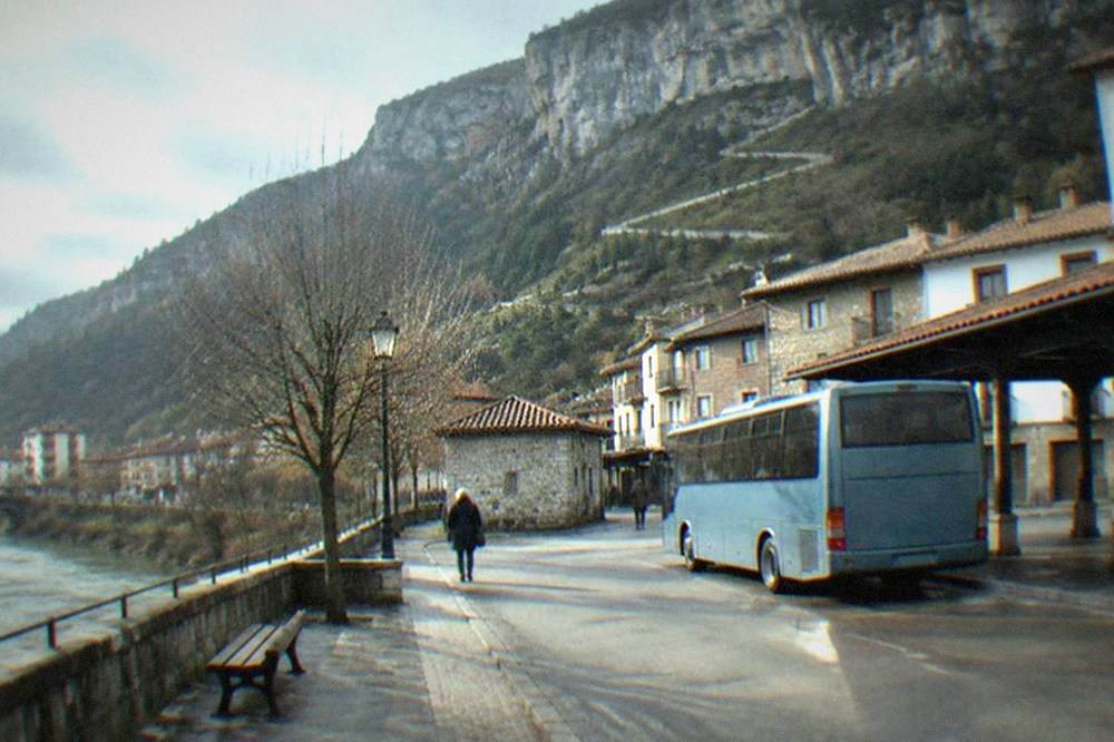 Regional bus parked at a small town station square in the Basque mountains