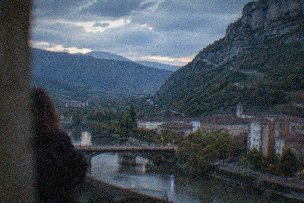 Winding road through green hills toward a distant inland Basque town