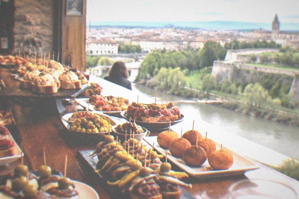 A counter of pintxo skewers and small plates in a Navarrese bar