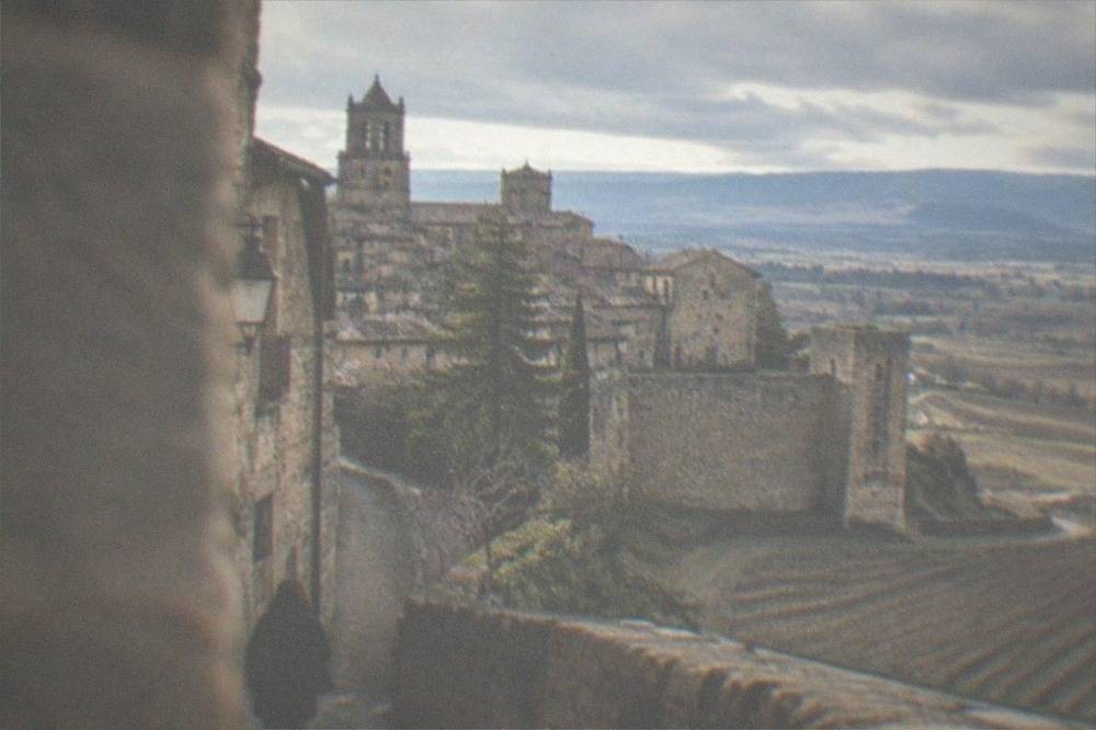 Stone walls and narrow towers of Laguardia rising above surrounding vineyards on a clear day
