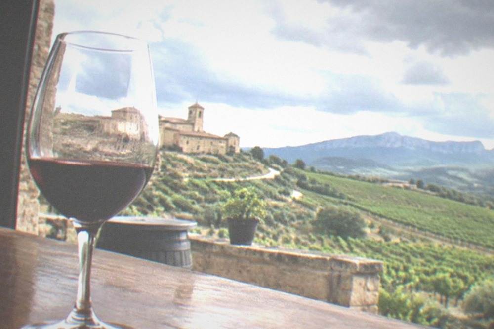 A glass of red Rioja wine on a wooden counter in a small village bar