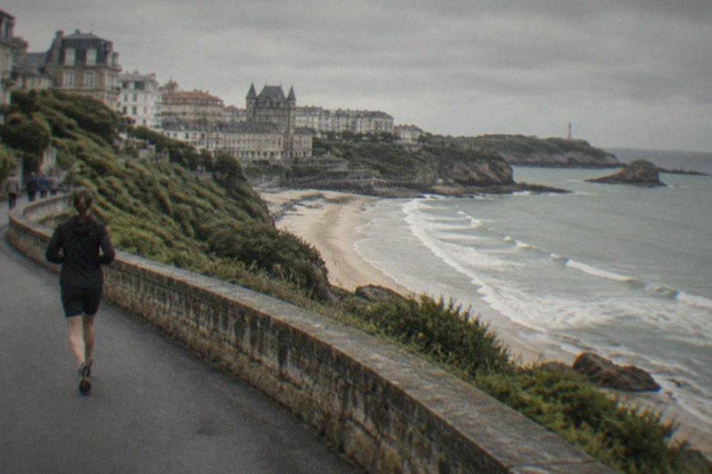 A coastal road winding along green cliffs above the Bay of Biscay
