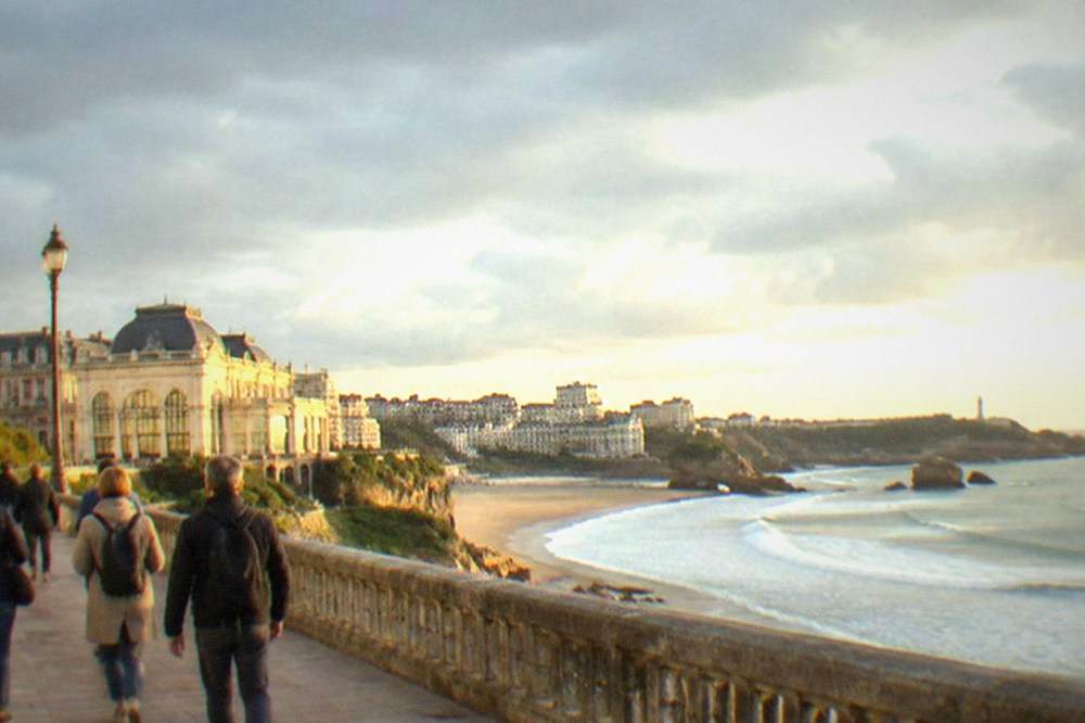 Tour group walking along the Biarritz seafront promenade near the casino