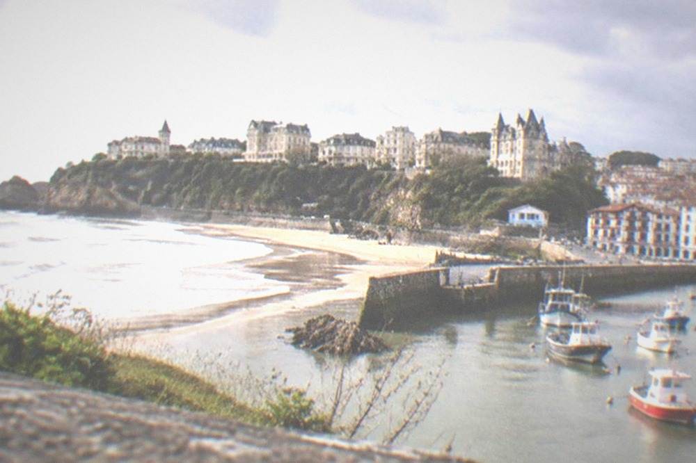 Fishing boats moored in the harbor of Saint-Jean-de-Luz with Basque houses behind