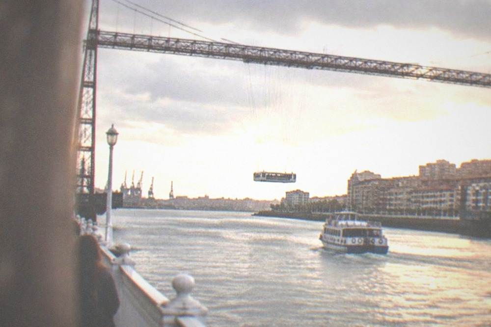 The iron span of the Vizcaya transporter bridge over the Nervion estuary with its suspended gondola crossing below