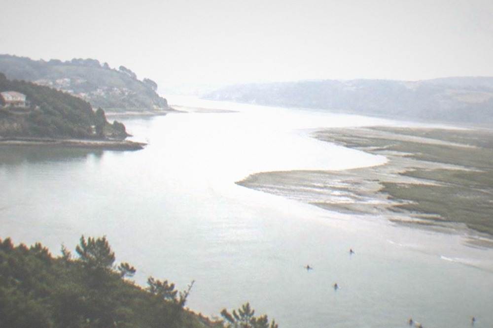 Surfers and the estuary channel seen from the viewpoint above Mundaka in Urdaibai