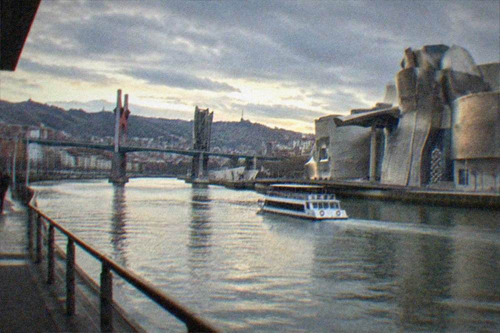 Panorama of Bilbao's Nervion estuary with the Guggenheim Museum and modern bridges at dusk