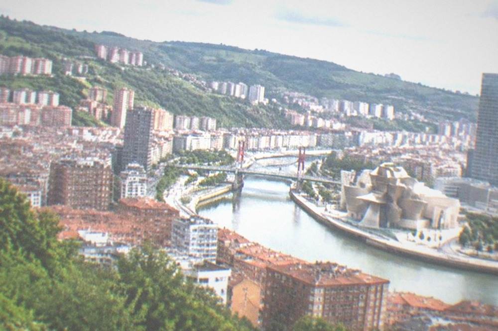 View from the Artxanda hillside over the Bilbao estuary and city skyline on a clear afternoon
