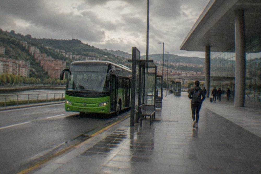 A Bizkaibus airport bus waiting at a stop outside the modern terminal building at Bilbao Airport