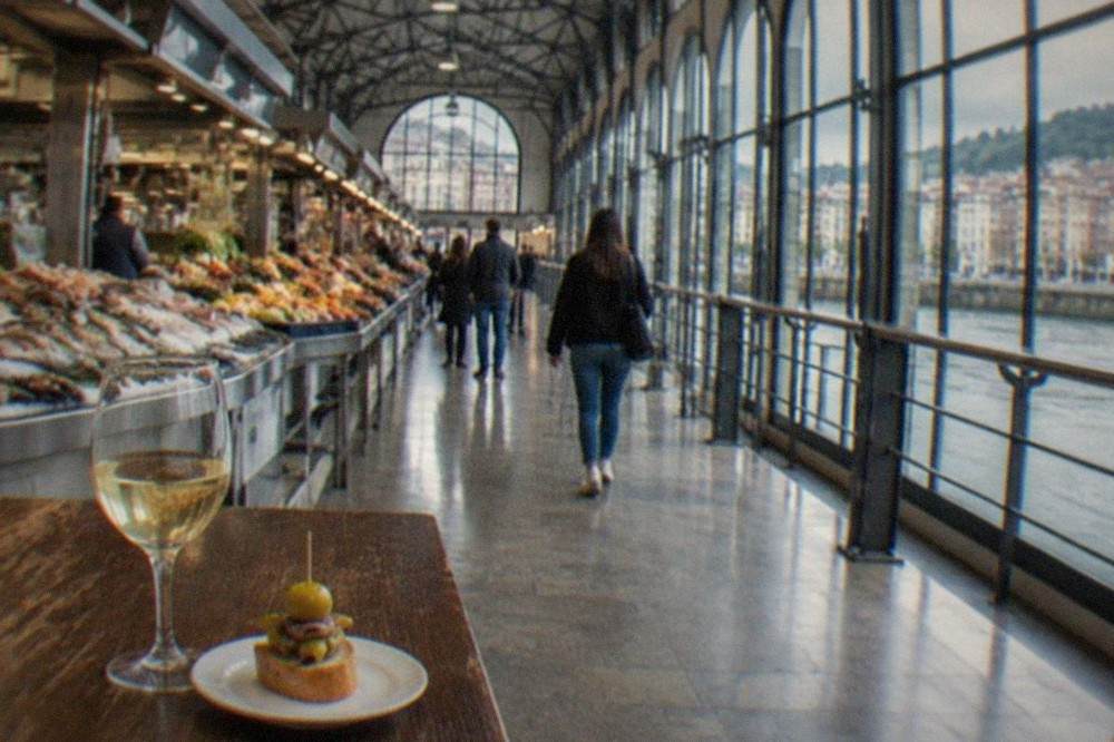 A small glass of txakoli wine and a skewered pintxo on a wooden bar top