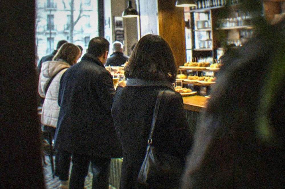 A busy pintxos bar interior in the Ensanche district with customers standing at the counter
