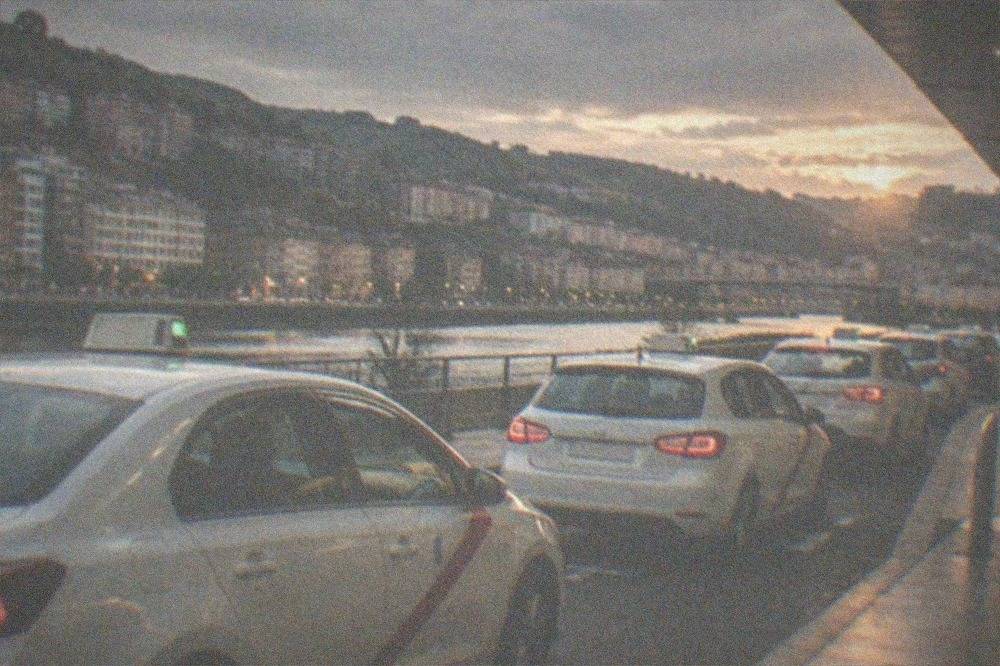 White taxis with red stripes waiting in a line at the airport rank at dusk