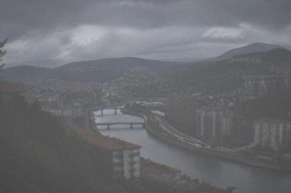 A view of green hills and clouds around the Bilbao area seen from the air