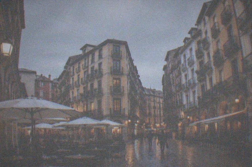 Evening light on the Seven Streets of Bilbao's Old Town with cafe tables on a cobbled square